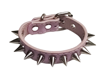 Light pink faux leather cuff bracelet with single row of cone spikes top view