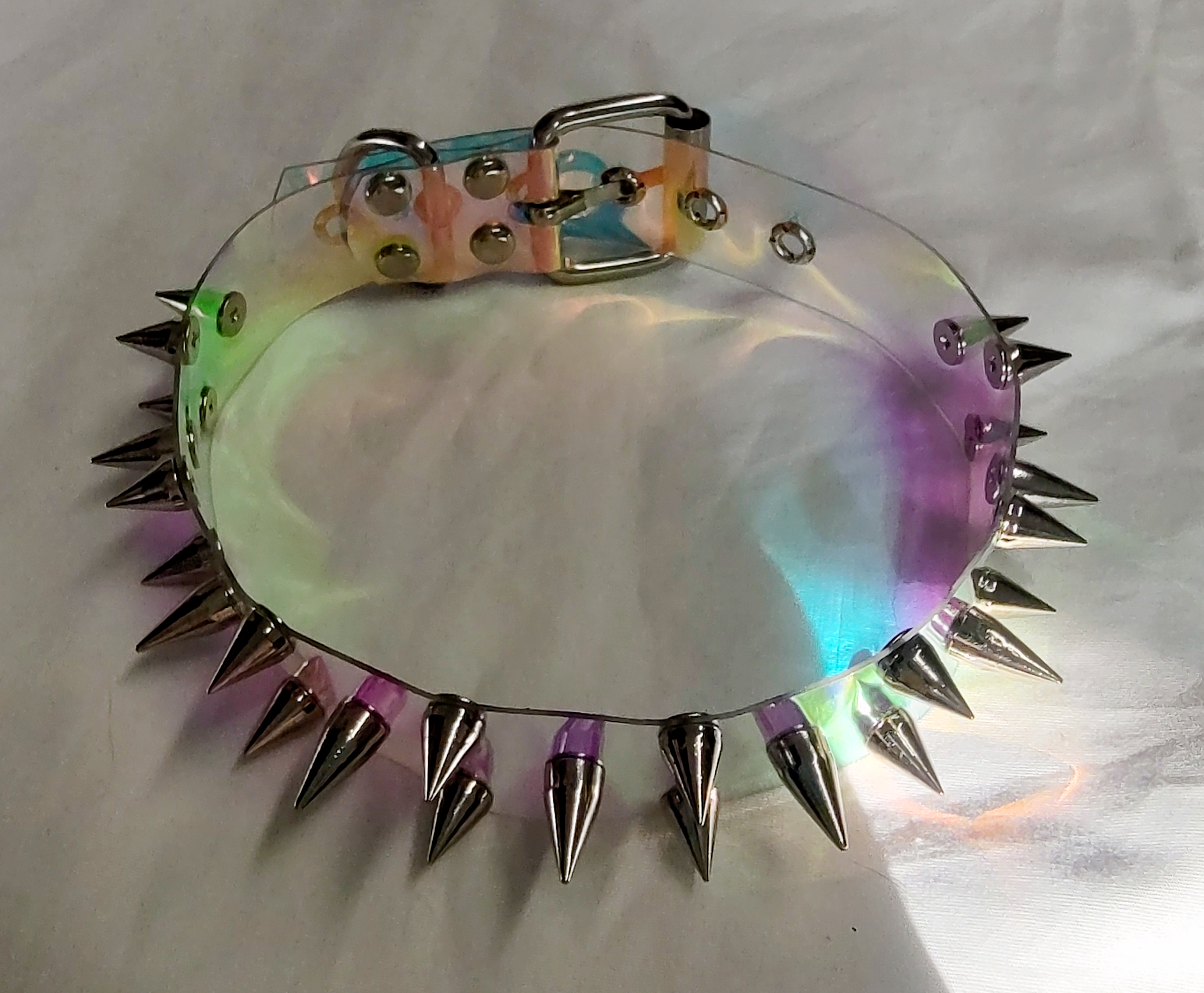 Clear plastic holographic iridescent choker collar with three rows of spikes top view