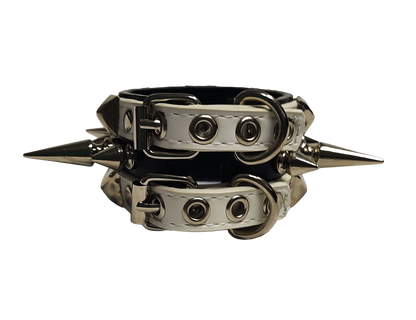 White and black faux leather cuff with alternating spikes and pyramid studs back view